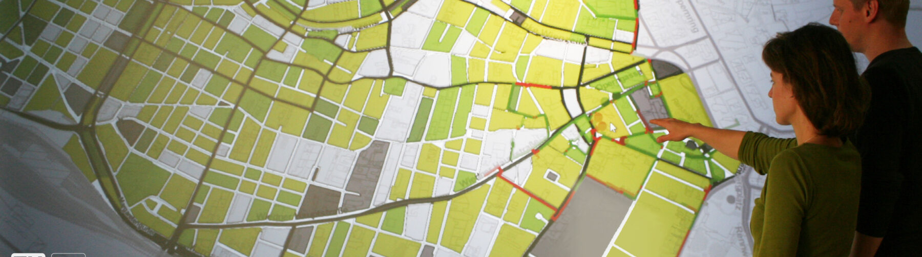 Two Simlab employees in front of a large city plan