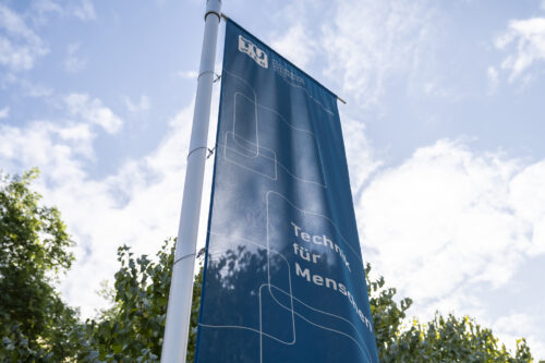 TU Wien flag right at Resselpark next to entrance of main building