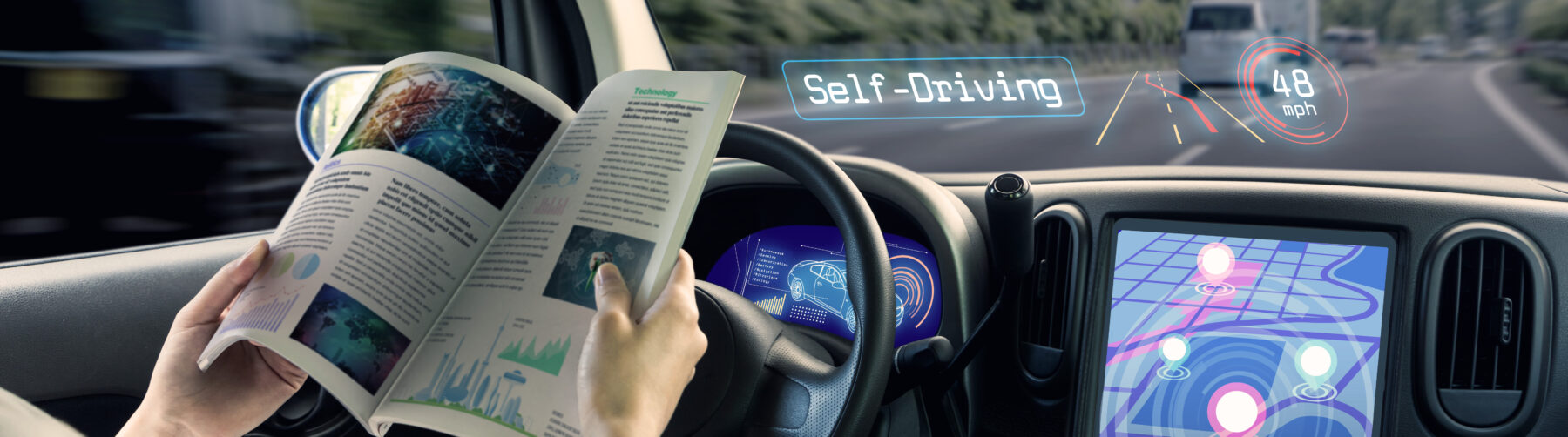 This picture depicts the cockpit of a self-driving car. The person sitting in the driving seat is reading a journal while the car is driving autonomously.