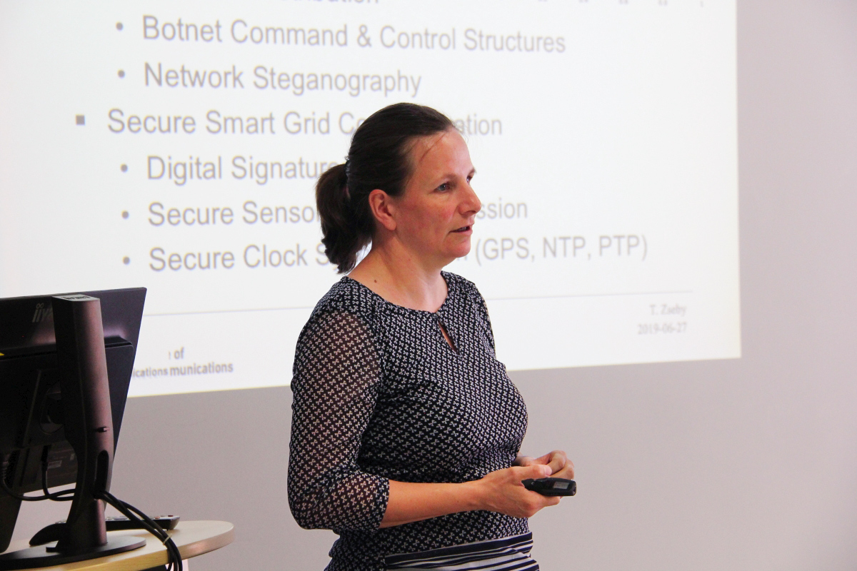 Prof. Tanja Zseby is standing and giving a lecture about ‘Malware Communication: Hiding Techniques and Detection