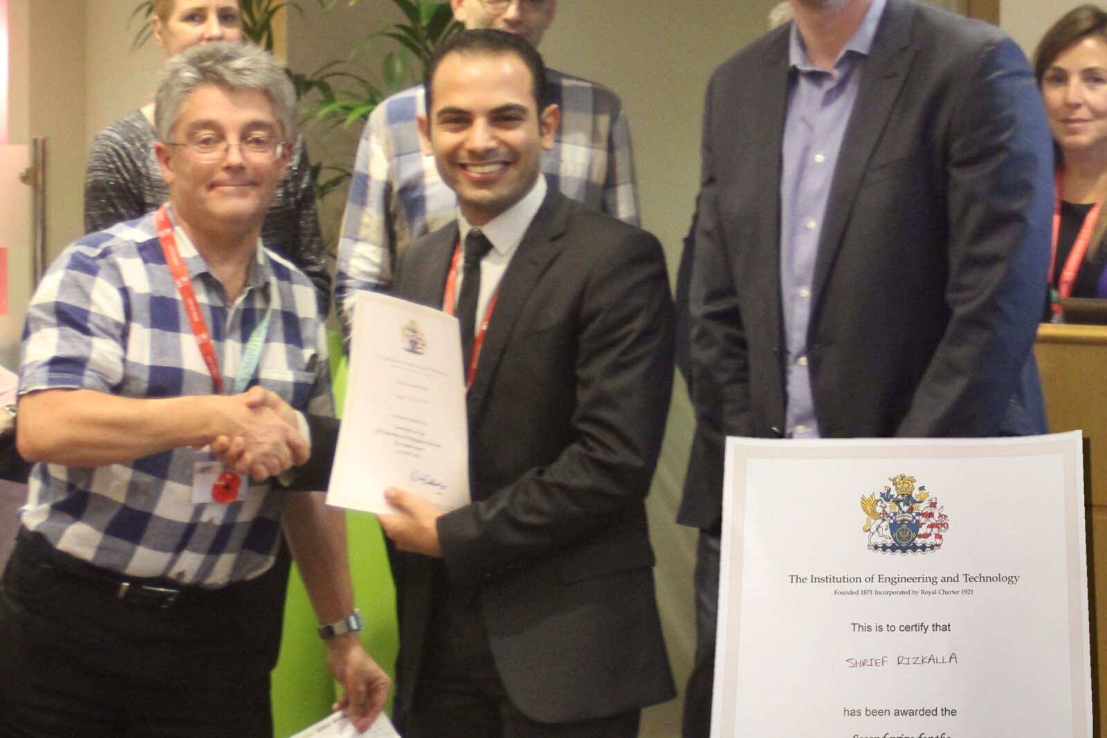 Shrief Rizkalla receives the certificate by Rob Lewis, BAE Systems, UK