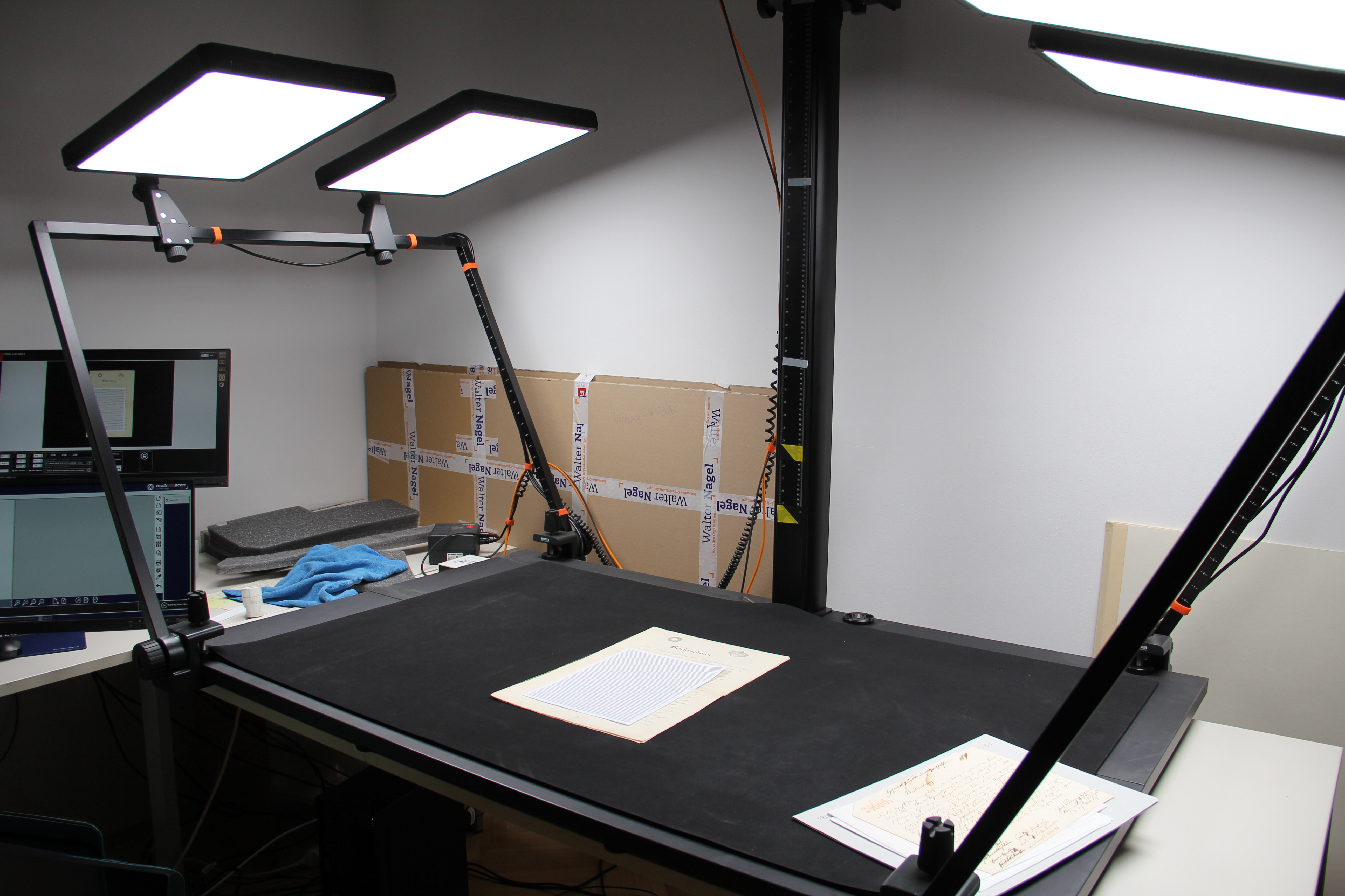 Tisch mit Leuchten und Papier für Digitalisierung