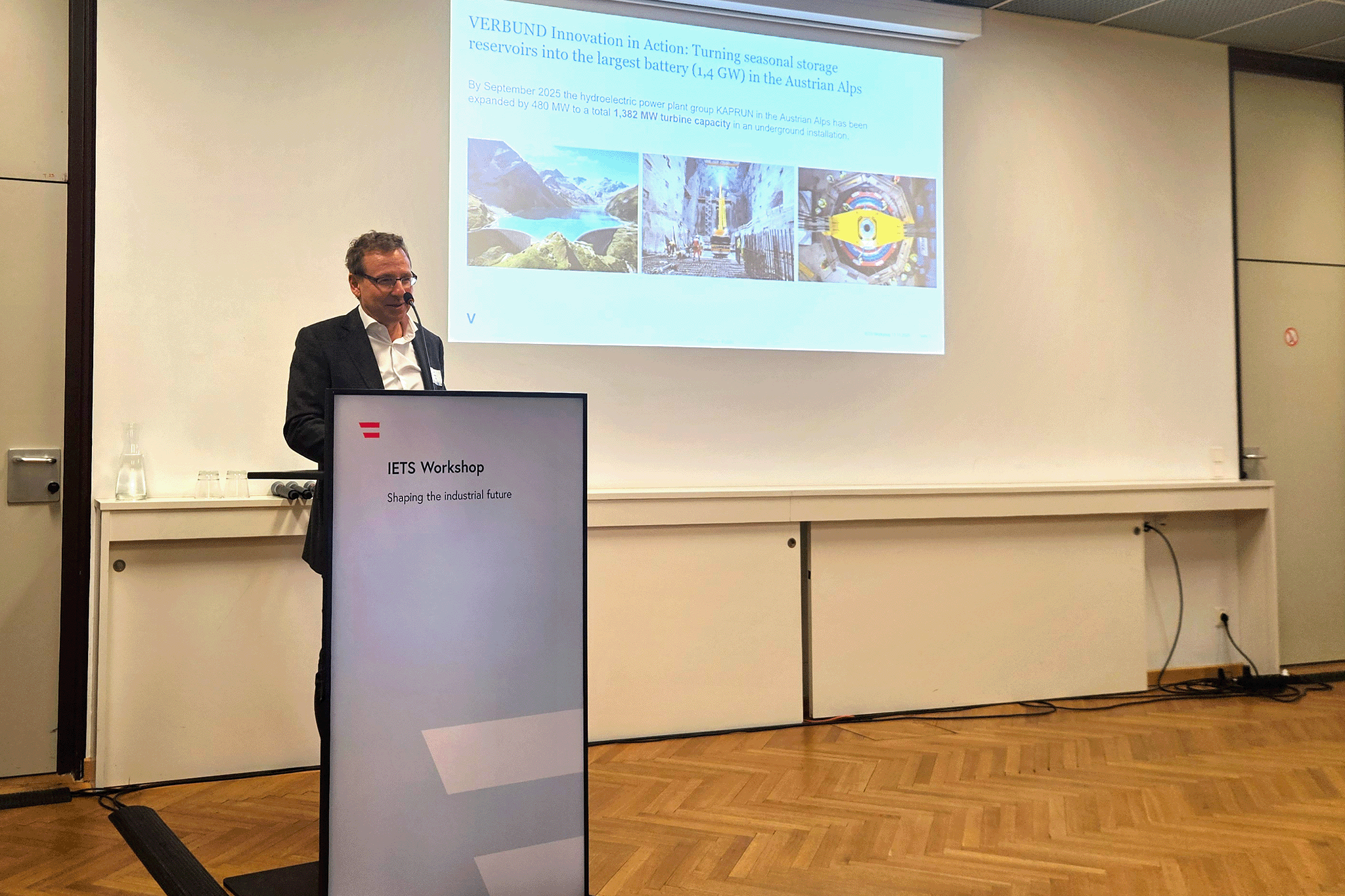 Conference-speaker behind high desk.