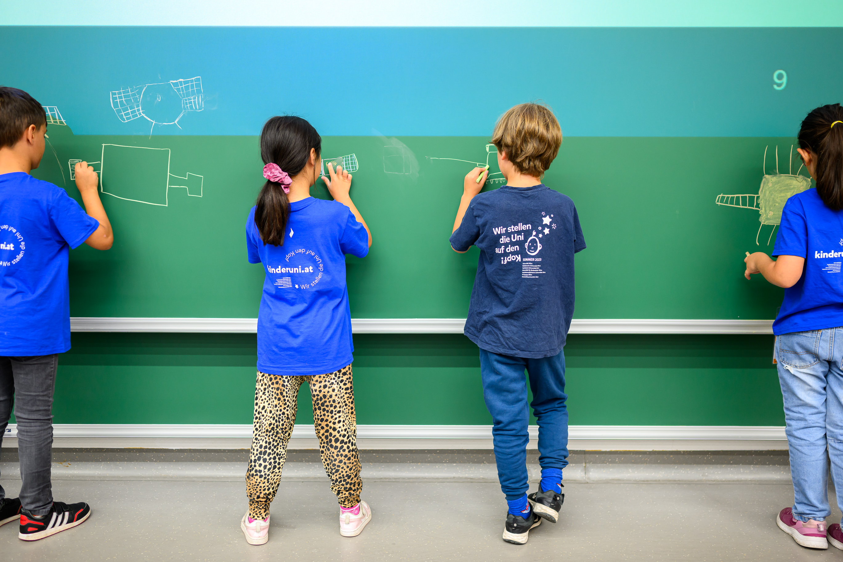 Kinder an Tafel von hinten