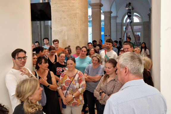 Wartende Menschen mit Prof. Emberger in der Aula der TUW.