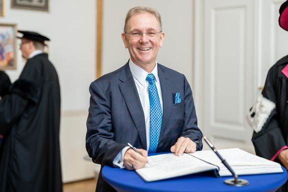 Peter Oswald unterschreibt im Ehrenbuch der TU Wien