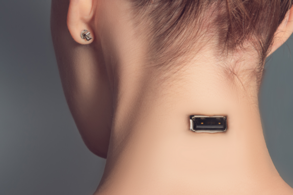 Hinteransicht eines Kopfes mit hochgesteckten Haaren. Im Nacken der Person befindet sich ein USB-Anschluss.