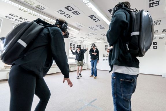 Gruppe von Burschen in VR-Brille spielen mit einander