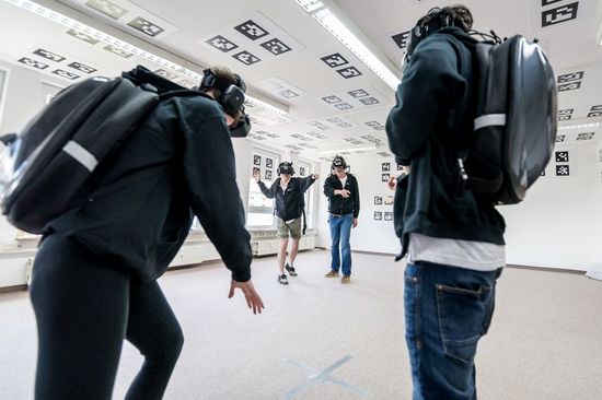 Gruppe von Burschen in VR-Brille spielen mit einander