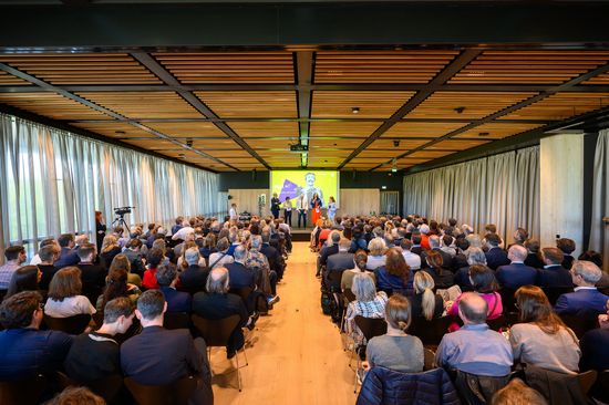 Saalaufnahme von der fuTUre fit Kick-Off Veranstaltung. Mehrere Menschen sitzen in Sesselreihen, auf der Bühne steht das Rektoratsteam