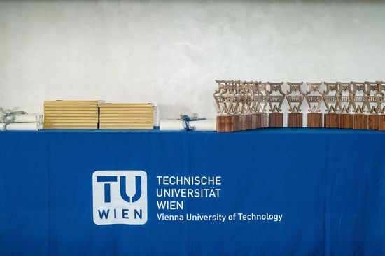 Best Teaching Awards Ein Tisch mit blauem Tischtuch, auf dem das TU Logo zu sehen ist. Darauf stehen die Urkunden und Best Teaching Awards.