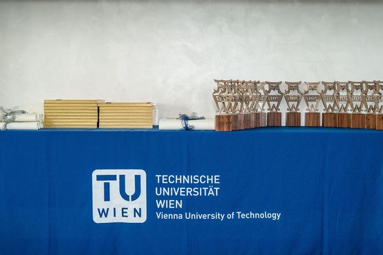 A table with a blue tablecloth on which the TU logo can be seen. On it are the certificates and Best Teaching Awards.
