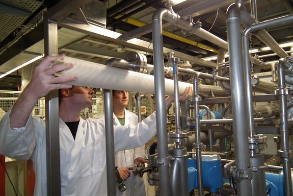 Zwei Mitarbeiter bestücken eine Anlage mit einer Nanofiltrations-Membran.