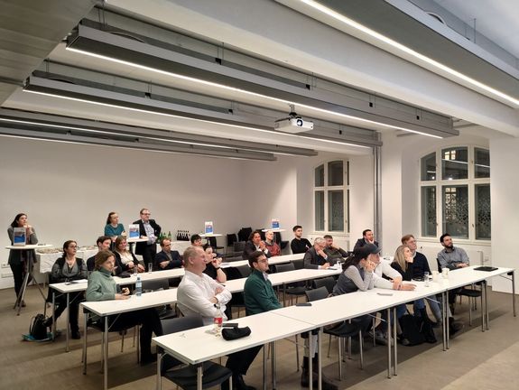 Alumni und Studenten (Frontalansicht) folgen dem Vortrag in einem Hörsaal