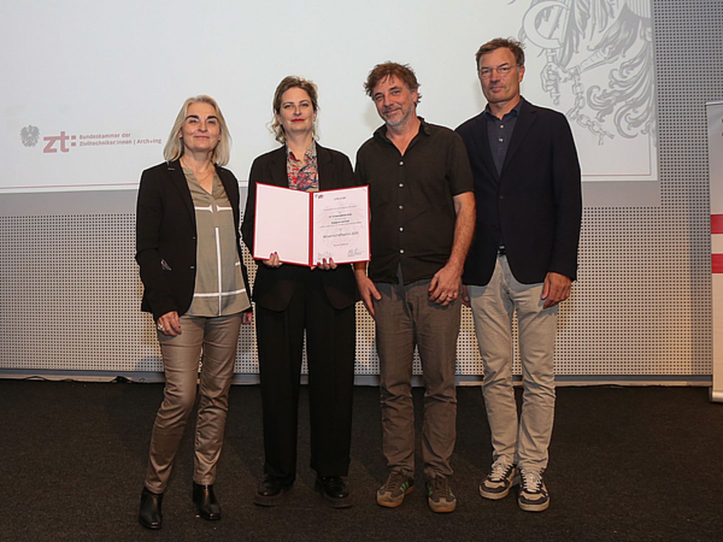 Gruppenfoto: von links nach rechts: Katharina Fröch (Vorsitzende der Bundessektion Architekt_innen), Bernadette Krejs, Norbert Trolf (Studiendekan der Fakultät für Architektur und Raumplanung), Daniel Fügenschuh (Präsident der Bundeskammer der Ziviltechniker_innen) 