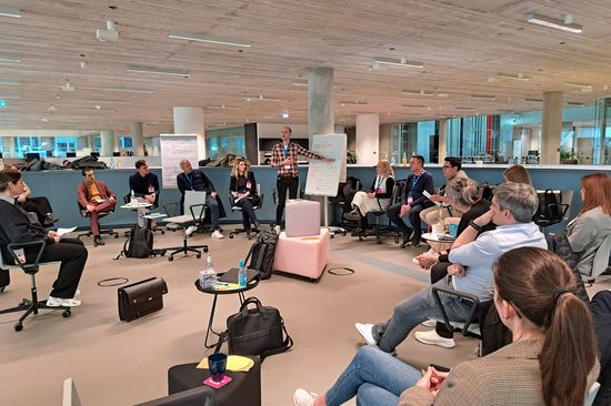 A group of students sitting and listening to a presentation by a comrade