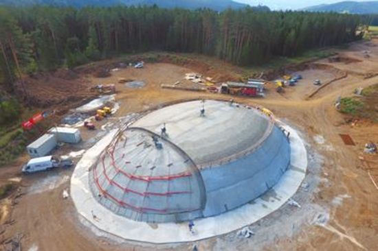 Aerial view of a large construction site erecting a double curved shell structure made of concrete  with link to video "Pneumatic forming of hardened concrete for double curved shell structures"