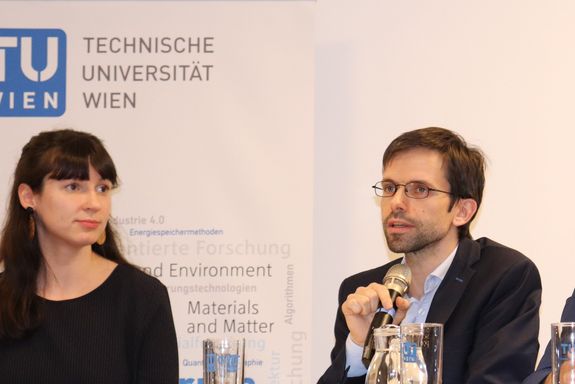 Eine Großaufnahme von Susanne Kaiser und Alexander Schirrer. Alexander Schirrer spricht ins Mikrofon.