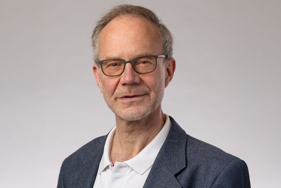 Portraitfoto Anton Arnold vor grauem Hintergrund