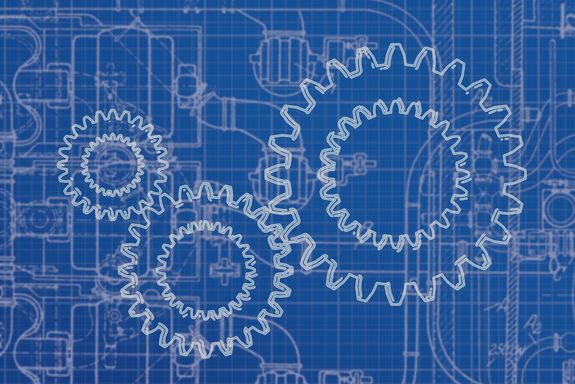 Zahnräder vor Hintergrund einer technischen Zeichnung