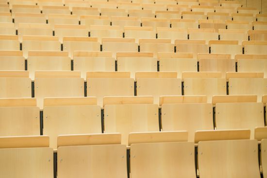 mehrere Reihen von Holzsitze in einem Hörsaal