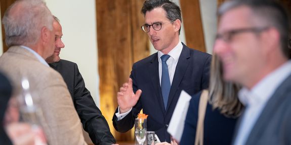 Bernhard Pichler stands with colleagues around a bar table and discusses.