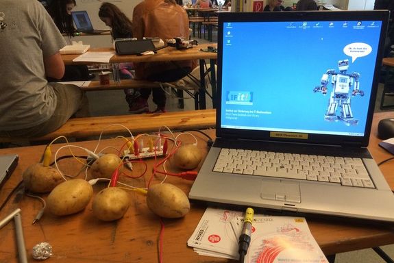 Ein Laptop ist durch den Kabel mit einem Kartoffel verbunden