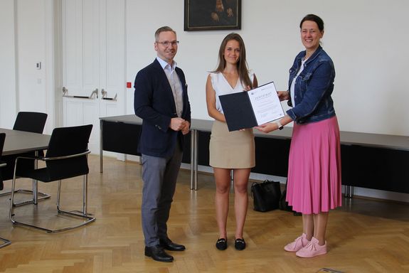 Personen stehend Roland Schmid, Pia Schwarzinger und Jasmin Gründling-Riener (von links)
