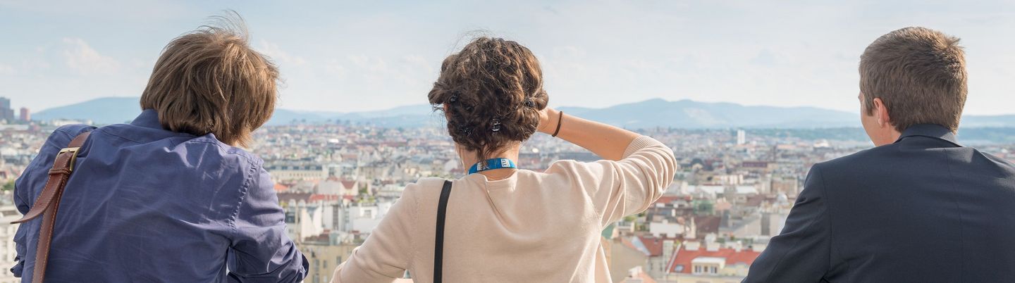 Two men, in the middle a woman, look over Vienna