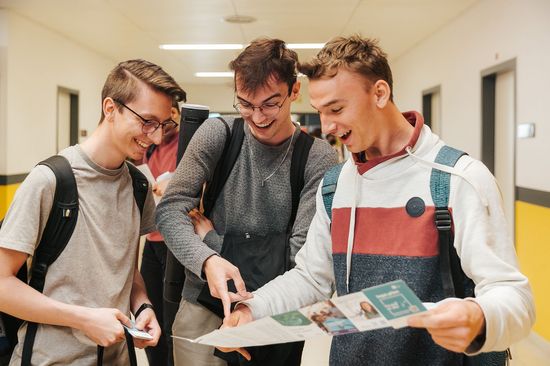 3 Personen stehend mit Übersichtsplan in den Händen
