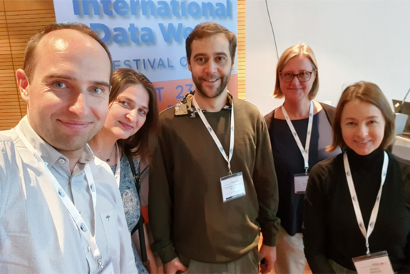 Fünf Personen vor einem Plakat der IDW 2023.