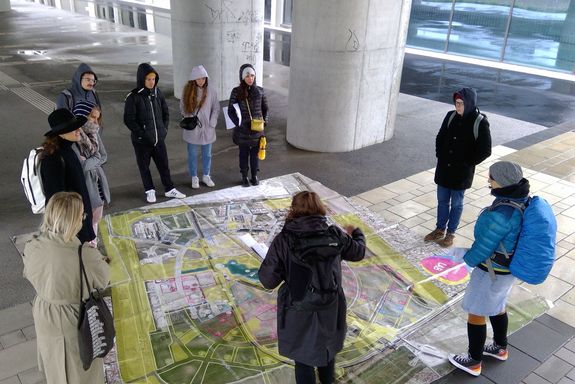 Studierende rund um einen großen Lageplan