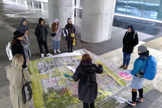 Studierende rund um einen großen Lageplan