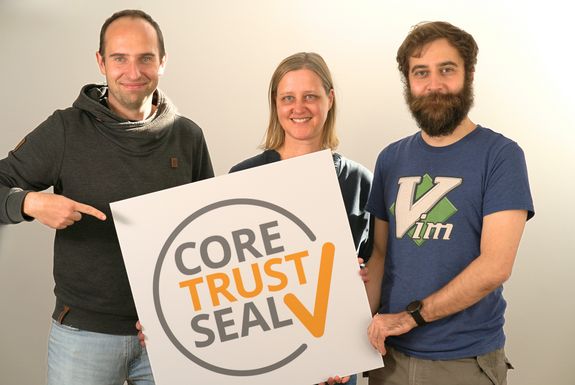Three people presenting a sign with the CTS logo.