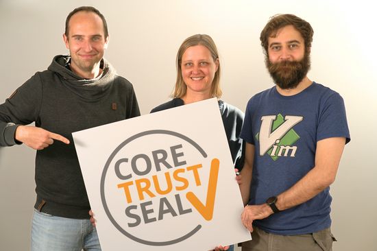 Three people presenting a sign with the CTS logo.