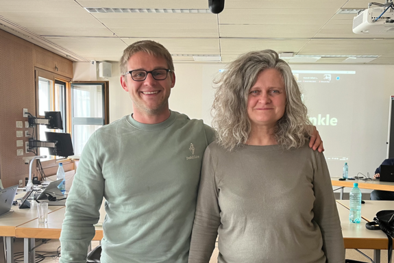 Zwei Trainer (Mann und Frau) lächeln in die Kamera