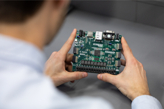 A person holds a small motherboard in their hands