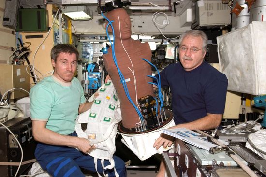 Die Messpuppe wird auf der Raumstation ISS in einen Raumanzug gepackt.