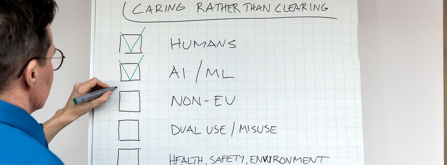 Flipchart with a checklist. Title: Caring rather than clearing. The checklist includes the following points: Humans; AI/ML; Non-EU; Dual Use/Misuse; Health, Safety, Environment; Other Issues