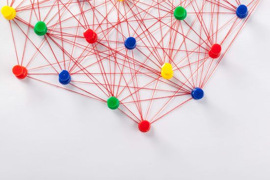 Stecknadeln verbunden mit rotem Faden