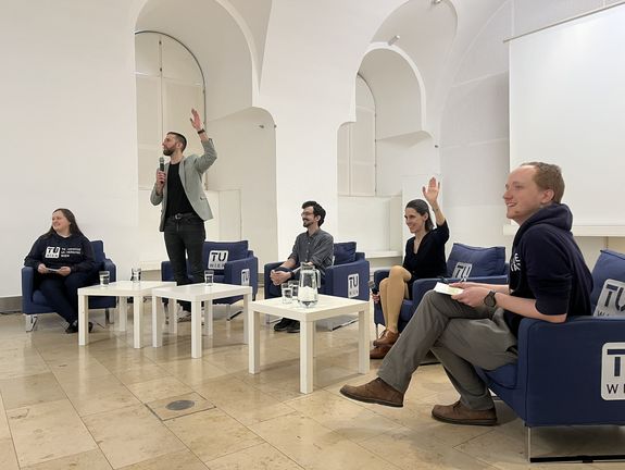 Diskussionsrunde mit Expert_innen - man sieht die Teilnehmer_innen am Podium