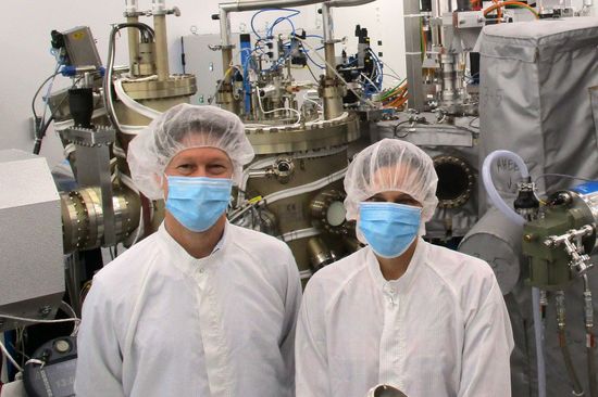 zwei Menschen mit Maske und Haarnetz im Reinraumlabor