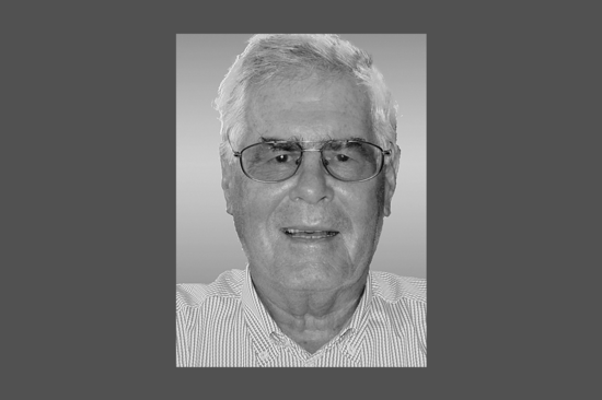 Schwarz-weiß-Porträtbild von Prof. Zeichen mit gestreiftem Hemd. Der Hintergrund ist grau.