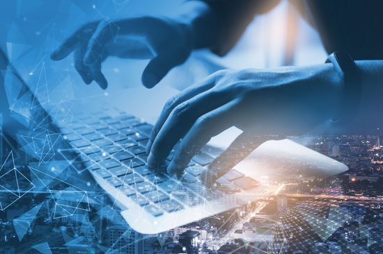 Ein Internet-Technologiekonzept, das eine Hand zeigt, die auf einem Laptop tippt.