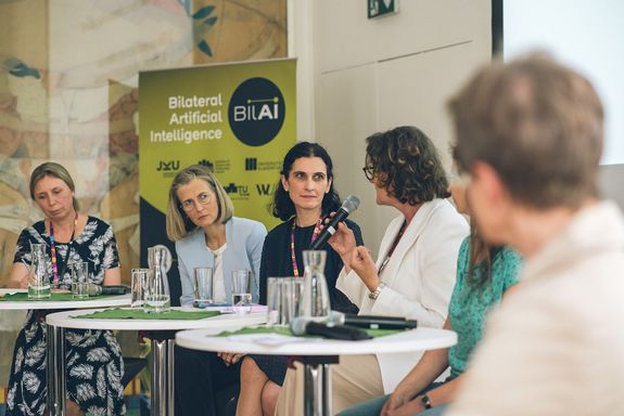 Frauen sitzend auf Podium, im Gespräch