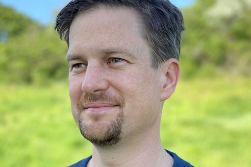Philipp Haslinger mit grüner Landschaft im Hintergrund