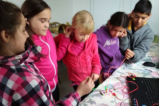 4 Mädchen und ein Bub im Volkschulalter beim interessierten Herumprobieren mit einer SOLE-Box zum Selbstlernen.