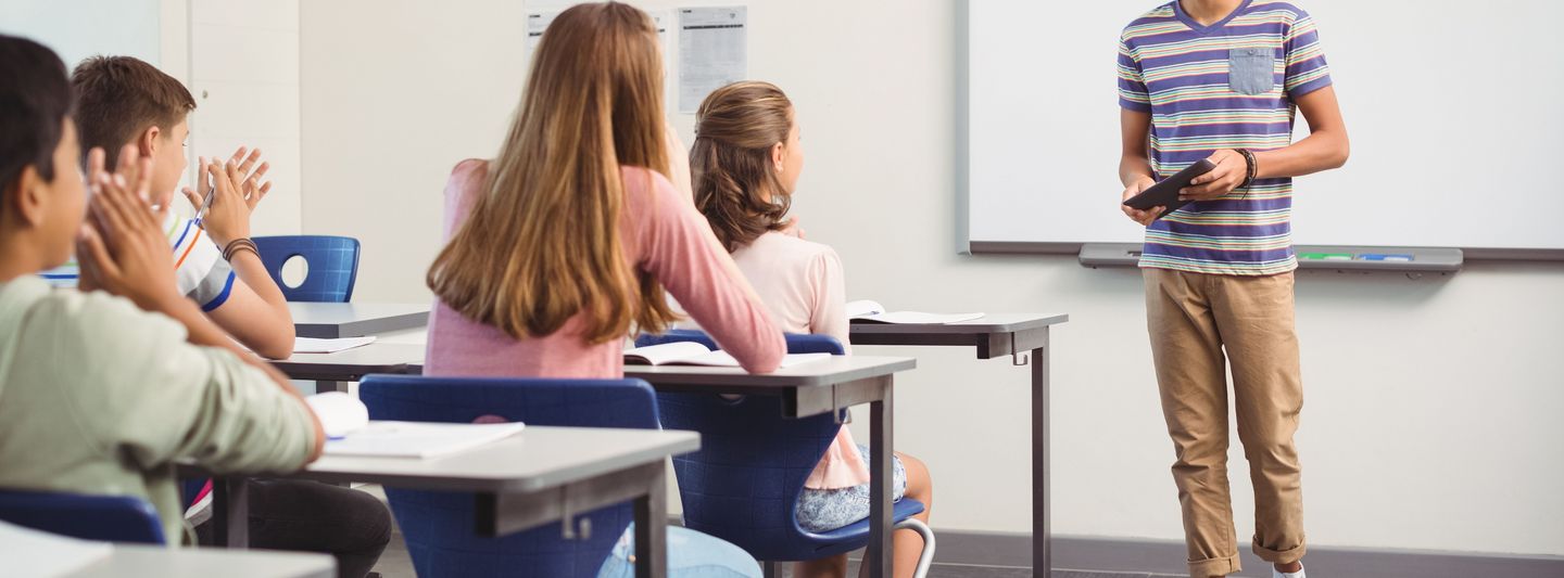 Ein Junge präsentiert vor einer Schulklasse.