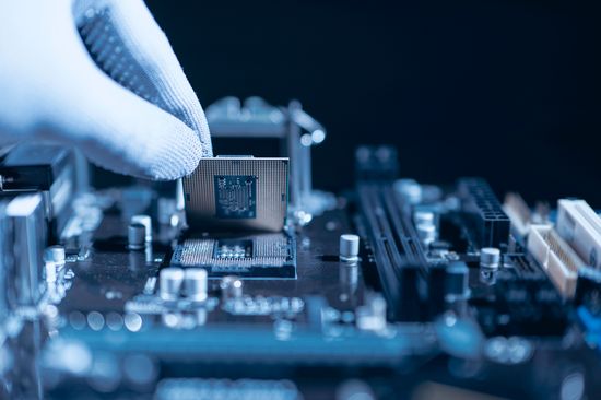 Techniker beim Einbau einer CPU in den Sockel der Hauptplatine. Computertechnik und Wartung oder Reparatur von Hardware.