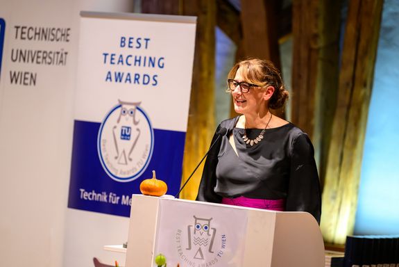Begrüßung Vizerektorin Lehre Jasmin Gründling-Riener stehend bei Pult mit Mikrofon